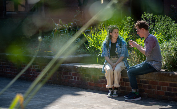 Two people sitting on a wall having a conversation